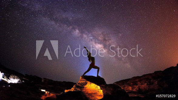 Picture of Landscape with Milky way galaxy Night sky with stars and silhouette woman practicing yoga on the mountain